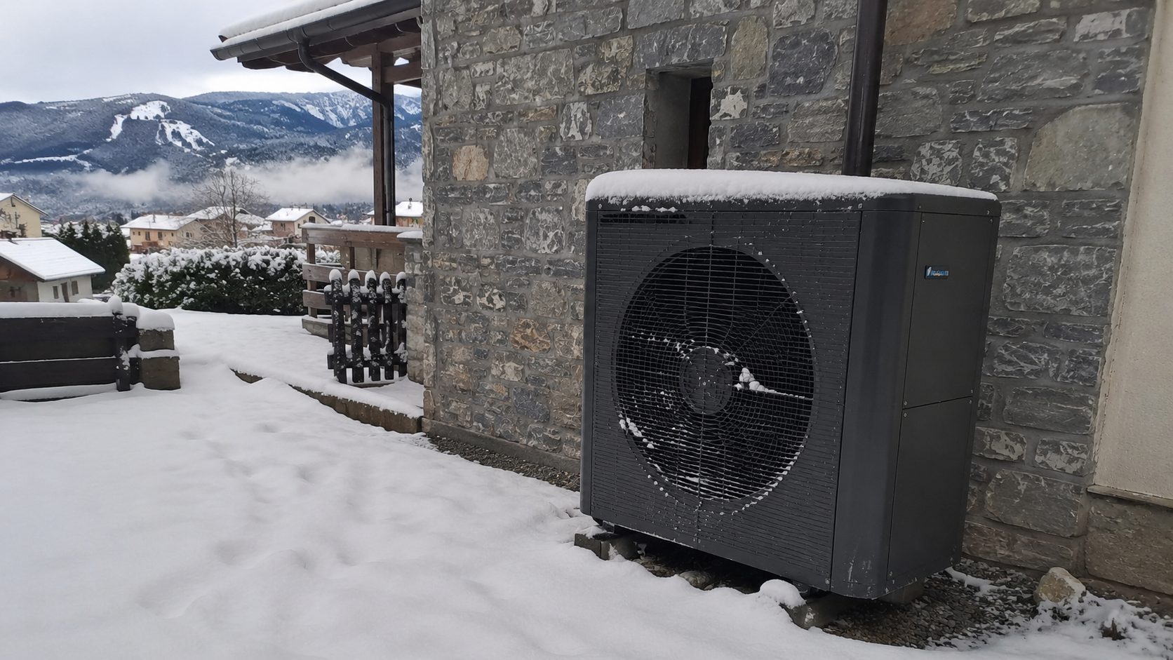 Unidad exterior de aerotermia instalada en una casa de montaña con nieve, demostrando su rendimiento real en zonas frías y clima extremo.