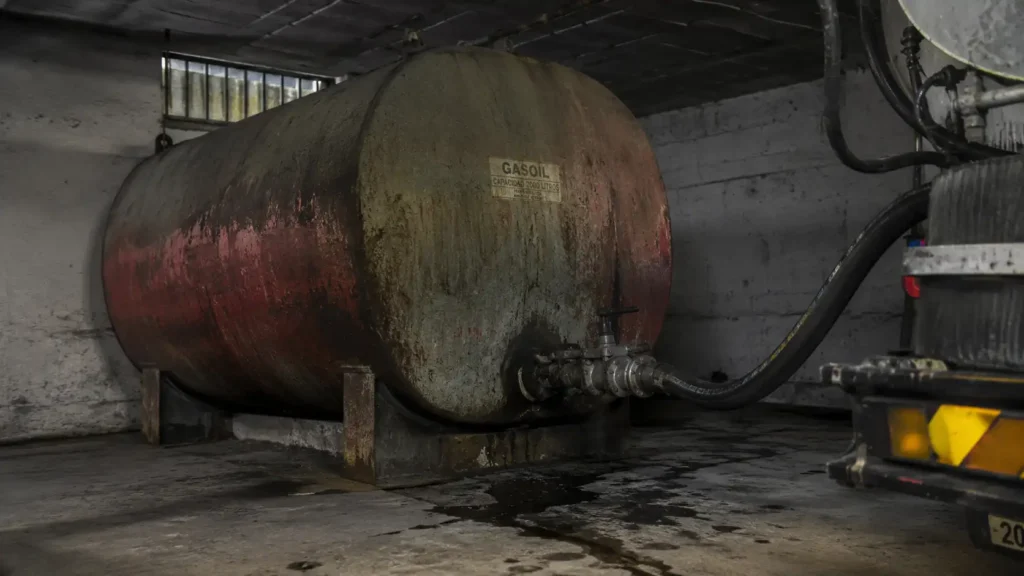 Depósito de gasoil antiguo y oxidado ocupando espacio en el garaje de un chalet antes de cambiar a aerotermia