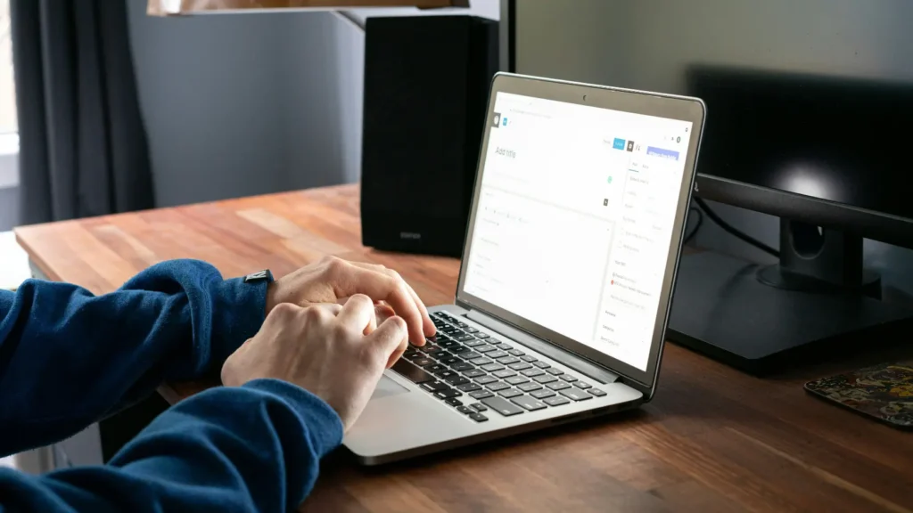 Persona revisando contrato de comercializadora en mesa con portátil sin datos visibles, representando el análisis de las cláusulas de batería virtual para compensación de excedentes