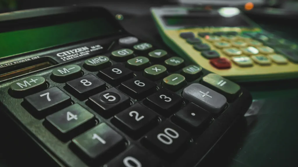 Formulario de declaración de la renta sobre escritorio con calculadora sin datos personales, representando los requisitos fiscales para la deducción del IRPF por instalación fotovoltaica